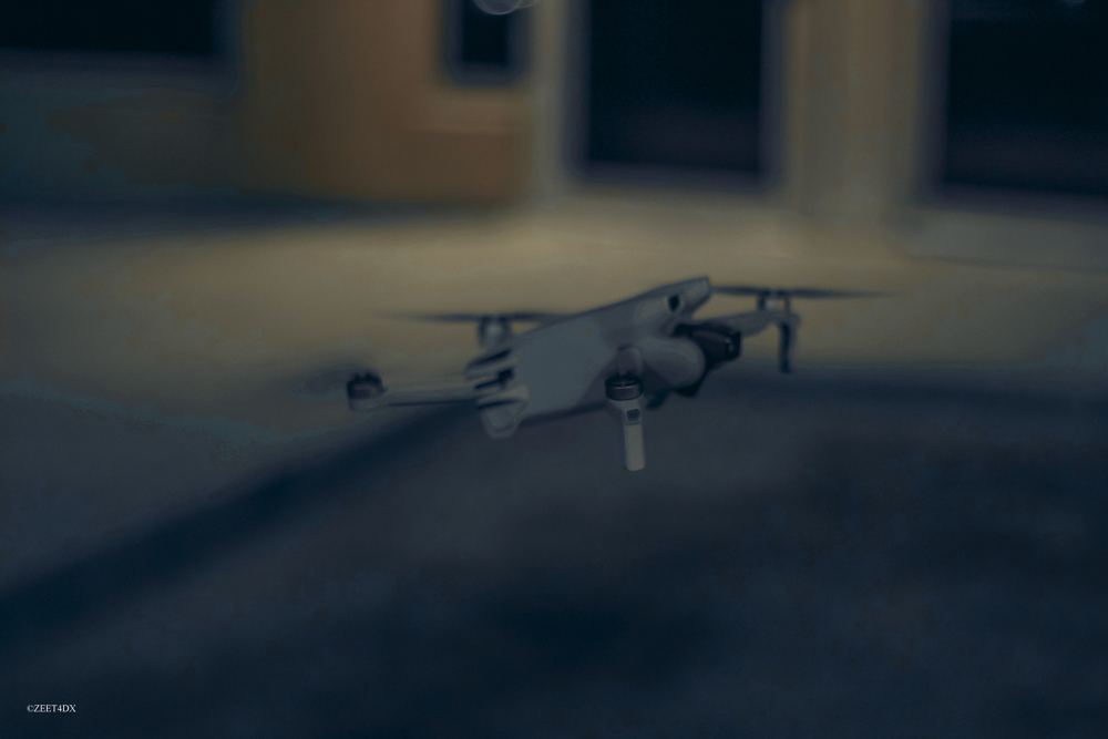 A small drone resting on the ground at dusk