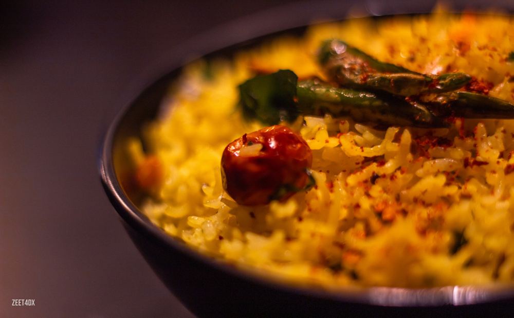 Close-up of saffron biryani with a red chili