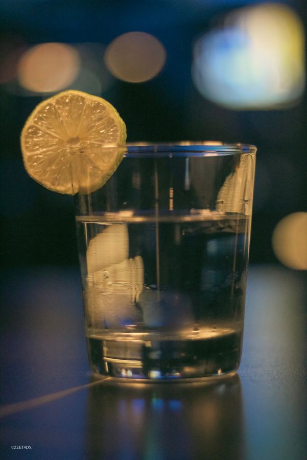 A glass with a lemon slice and warm bokeh