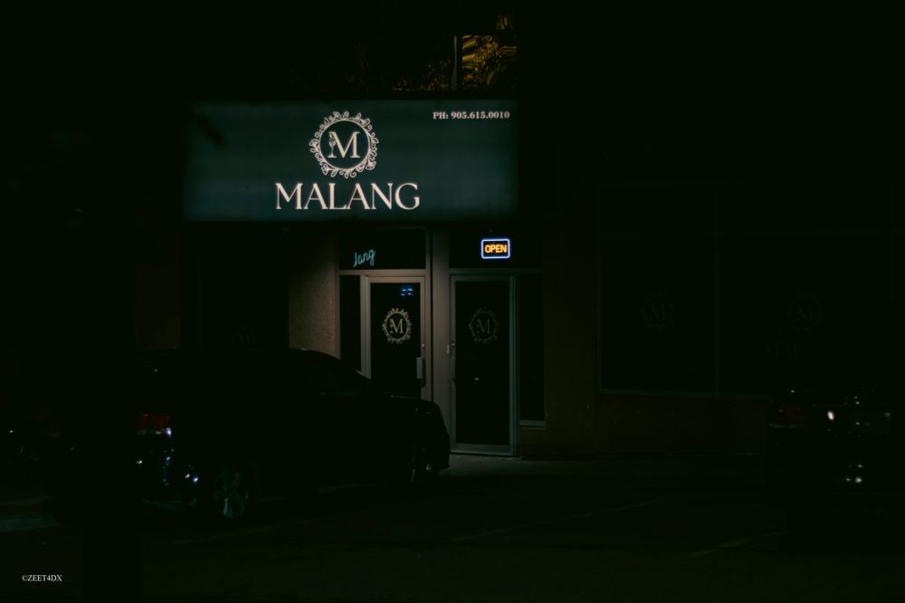 Lounge entrance with a lit sign at night