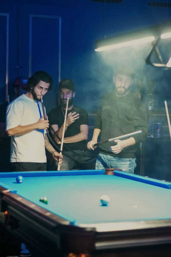 Friends playing pool in a hazy lounge